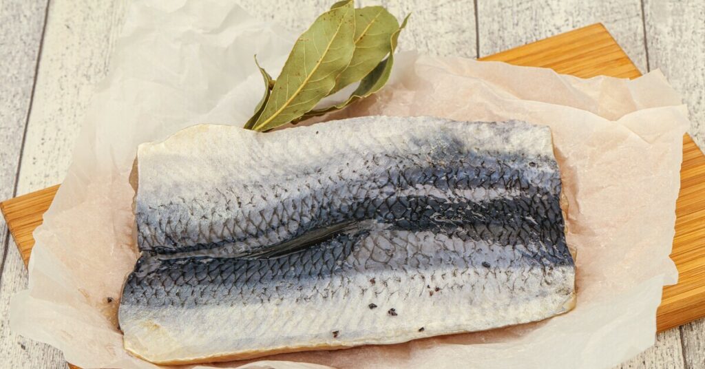 Filet ryby na tle naturalnych składników, idealny do przyrządzania zdrowych potraw.