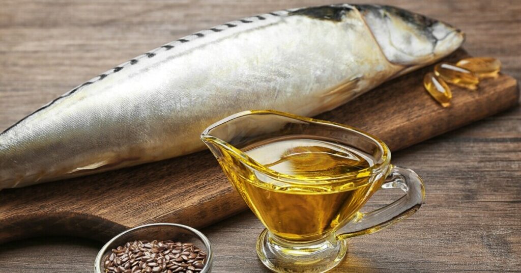 Świeża makrela na drewnianej desce obok miseczki z nasionami lnu oraz butelki olajku rybnego, co podkreśla zdrowe właściwości diety bogatej w omega-3.