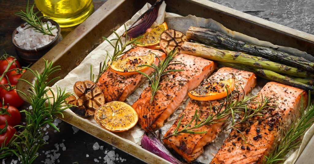 Pyszny filet z łososia pieczony z aromatycznymi ziołami, cytrusami oraz grillowanymi warzywami, idealny na zdrowy obiad.