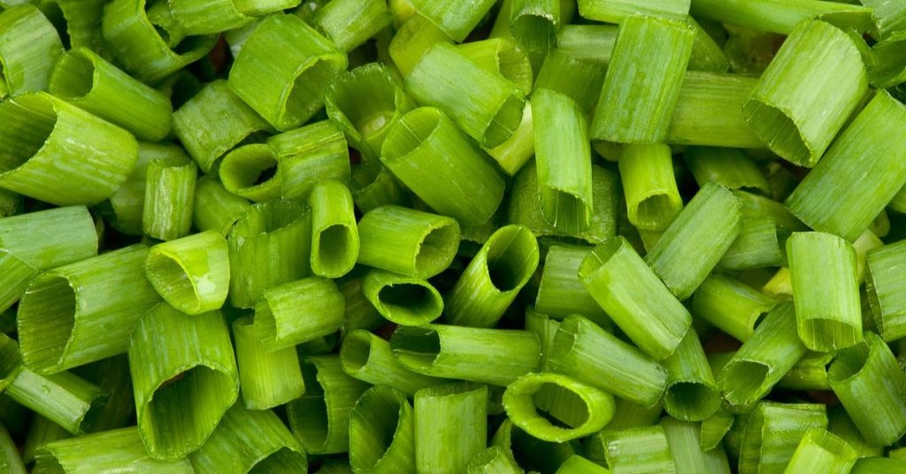 Obraz przedstawia świeże pokrojone szczypiorki, idealne do wykorzystania w sałatkach i potrawach jako aromatyczna przyprawa.