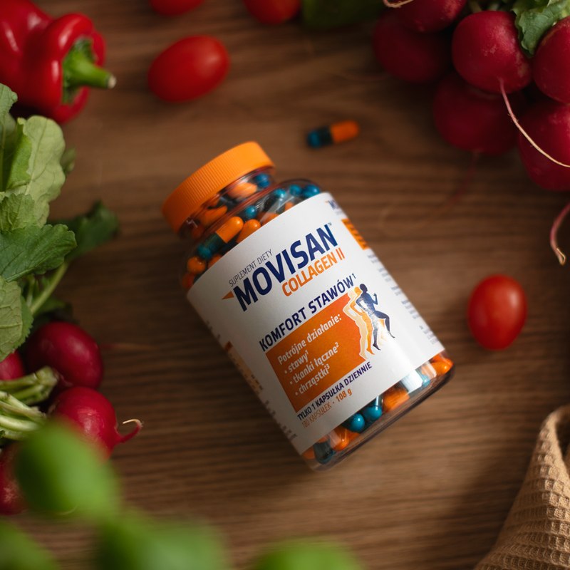 Butelka suplementu diety Movisan Collagen II z kapsułkami wspierającymi komfort stawów, otoczona świeżymi warzywami.