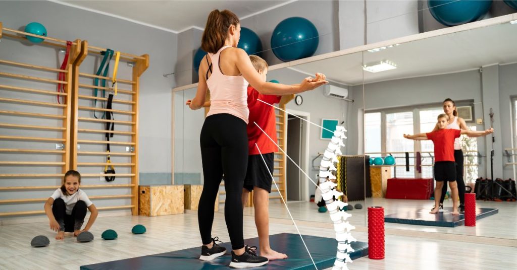 Dzieci uczestniczą w zajęciach sportowych, ucząc się technik równowagi i koordynacji w nowoczesnej sali treningowej.