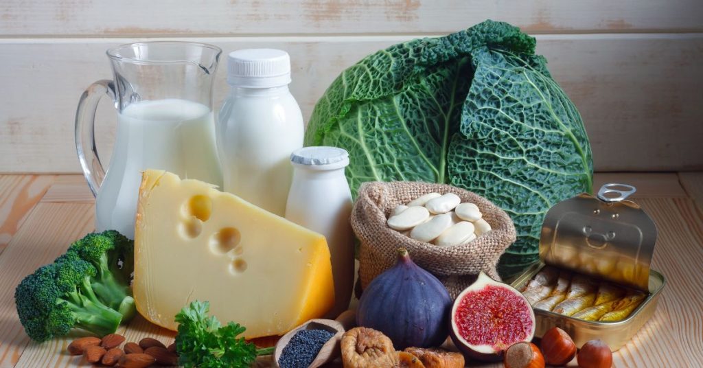 Na zdjęciu przedstawione są zdrowe produkty spożywcze, takie jak świeże warzywa, sery, mleko, orzechy oraz suszone owoce, które wspierają zrównoważoną dietę.