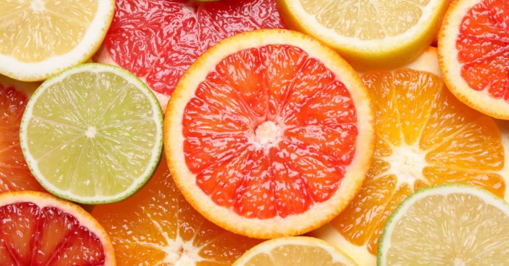 Kolorowe plasterki cytrusów, w tym grejpfruty, pomarańcze, limonki i cytryny, tworzą apetyczną kompozycję pełną świeżości i witamin.