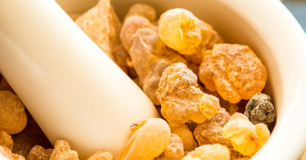 Moździerz i tłuczek zawierający kawałki aromatycznej żywicy, powszechnie stosowany w naturalnych środkach leczniczych.